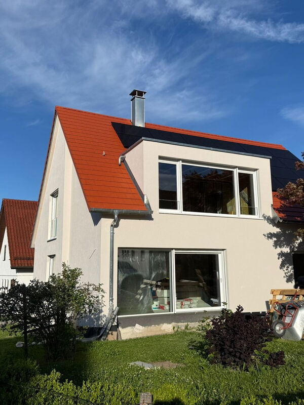Fertig gedämmte Fassade mit großer Gaube – Gartenseite