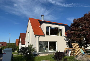 Fertig gedämmte und verputzte Fassade eines Einfamilienhauses nach der WDVS-Sanierung
